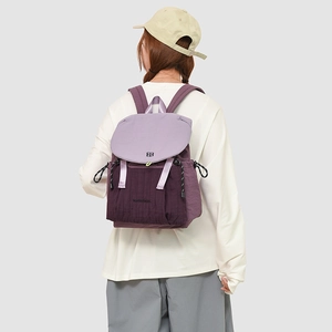 Detail eines Rucksacks im Color-Block-Design mit lila Klappe und plissierter Textur