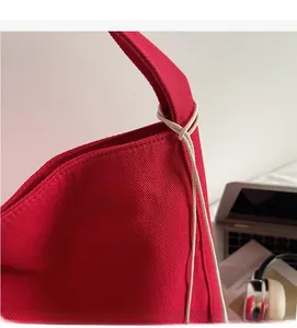 Dettaglio della borsa tote in tela rossa con trama in twill e corda bianca decorativa
