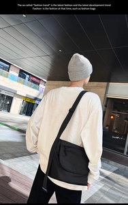 Scatto street style all'aperto della borsa a tracolla nera con ampia tracolla sul modello