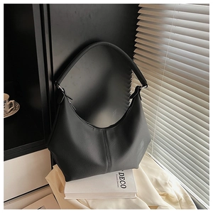 Détail du sac hobo en cuir grainé noir avec coutures et bandoulière large élégante