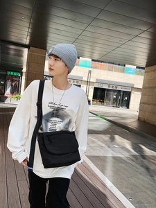Stile street outdoor con borsa a tracolla nera abbinata a una t-shirt bianca casual