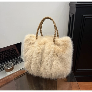 Detailansicht der aprikosenfarbenen Plüschtasche mit geflochtenem braunem Kunstledergriff