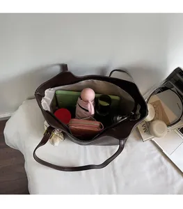 Top view of spacious interior in dark brown leather tote bag with daily items inside