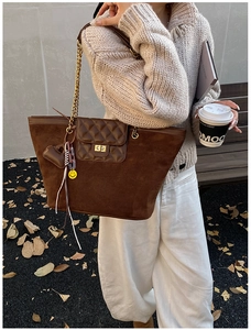 Detail of vintage brown suede tote bag with diamond quilted flap and gold chain strap