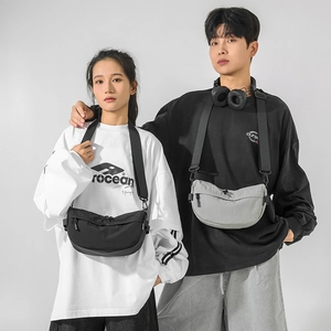 Détail de couple portant des sacs bandoulière en nylon noir et vert clair