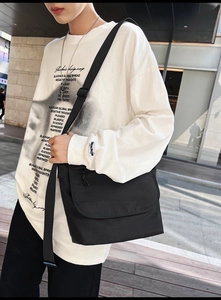 Dettaglio di una grande borsa a tracolla in nylon nero con cinturino regolabile urban