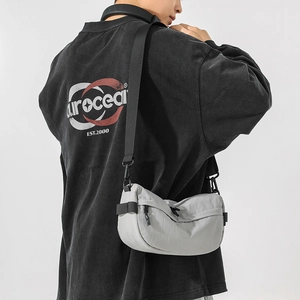 Détail d'un sac bandoulière croissant en nylon gris léger avec sangle noire ajustable