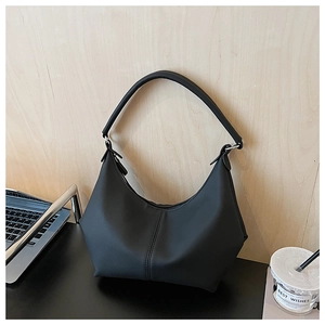 Détail du sac hobo noir minimaliste avec finition mate et couture verticale centrale
