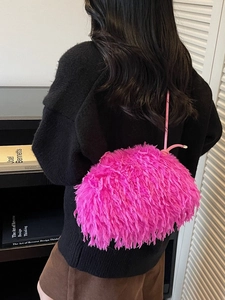 Sac à épaule en fausse fourrure rose vif avec fines bretelles porté par un modèle