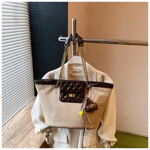 Detail of retro matte tote bag with diamond quilted pocket and heart charm chain