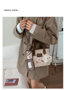 Chic cream canvas cat print bucket bag shown on model with star plush charm and card holder