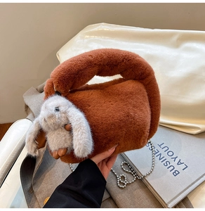 Detail view of brown plush crossbody bag with bunny ears and metal chain strap