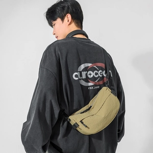 Sac bandoulière demi-lune kaki en nylon porté par un homme, vue de dos du sac