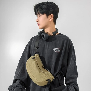 Mannequin masculin portant un sac bandoulière en nylon kaki avec sangle noire