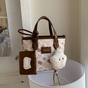 Detail of cartoon bread cat pattern on checkerboard tote bag with star charm