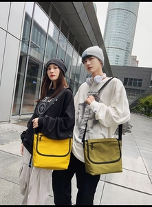 Vista ravvicinata della borsa messenger gialla in tela con tracolla regolabile in nylon nero