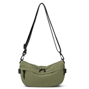 Détail du sac demi-lune en nylon vert militaire avec étiquette de marque et zip noir