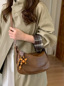 Retro brown leather crescent shoulder bag with wooden bead charm and adjustable strap