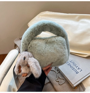 Detail of light green plush handbag featuring a cute rabbit charm and silver bead chain