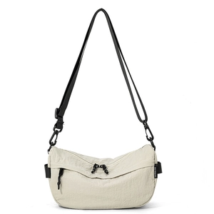 Détail du sac bandoulière demi-lune crème avec tissu froissé et fermeture éclair noire