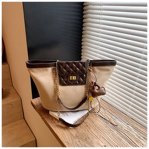 Close-up of vintage tote bag with beige suede, brown quilted leather and gold chain strap