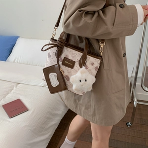 Detail view of the cream cartoon cat tote bag with matching coin purse and star pendant