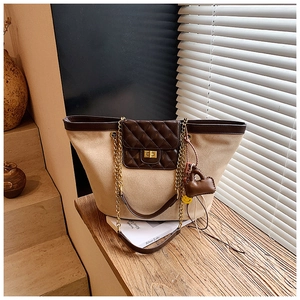 Detail of vintage canvas tote with quilted leather pocket and golden chain strap