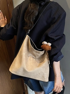 Chic beige faux suede oversized tote bag with plush bear charm and black trim detail