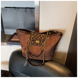 Close-up of vintage brown matte tote with quilted pocket and gold chain strap detail
