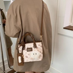 Detail of cartoon cat pattern shoulder bag with star plush charm and mini pouch