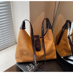 Detail of retro suede shoulder bag with glossy leather strap and magnetic flap button