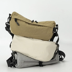 Gros plan de sacs bandoulière en nylon léger aux couleurs kaki, blanc et gris