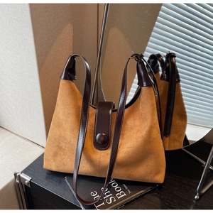 Mirror reflection showing details of a brown suede hobo bag with sleek buckle and shoulder strap