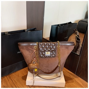 Detailed close-up of large tote bag with suede texture, metal lock, and chain strap