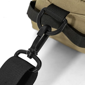Gros plan du sac en nylon kaki montrant la sangle noire et les détails du crochet