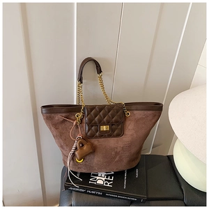 Close-up of brown suede tote bag featuring a diamond pattern pocket and gold chain strap