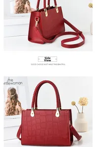 Detail view of red crocodile pattern handbag with golden hardware and top handles