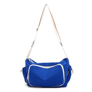 Detail of blue nylon crossbody bag featuring contrast trim and adjustable white strap