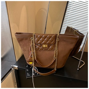 Detailed close-up of retro brown tote bag with quilted leather and golden chain strap