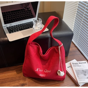 Dettaglio della borsa tote in tela rossa con ricamo bianco e design capiente ed elegante