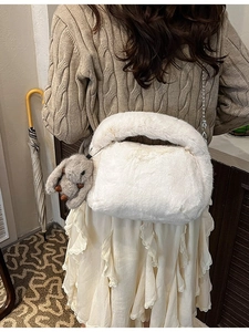 White fluffy plush handbag with chain strap and bunny charm for winter outfits