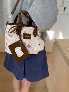 Cartoon cat print canvas bucket bag with brown leather trim and cute plush charms
