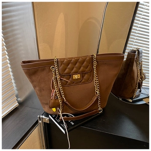 Detail of vintage brown tote bag with diamond quilted flap and gold chain strap