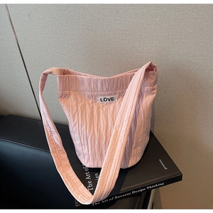 Detailed texture of pink pleated nylon shoulder bag featuring a white LOVE label patch