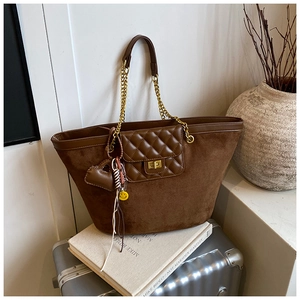 Close-up of vintage brown tote bag with suede textures, gold chain straps and heart charms
