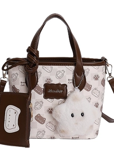 Cartoon cat printed tote bag with brown trim and plush star charm on white background