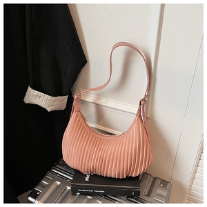 Detailed view of pink pleated shoulder bag with adjustable strap and textured vegan leather