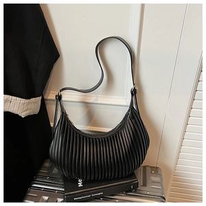 Detail of black pleated crescent shoulder bag with vertical accordion folds and hardware