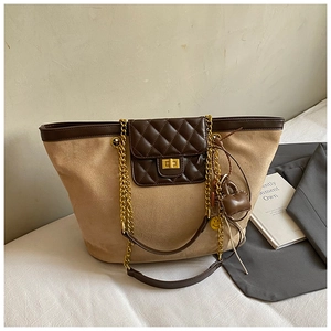 Close-up of matte suede tote bag featuring a leather diamond-quilted pocket and chain strap