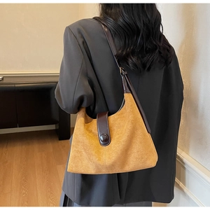 Detail of vintage crossbody bag with ginger suede texture and dark brown leather accents